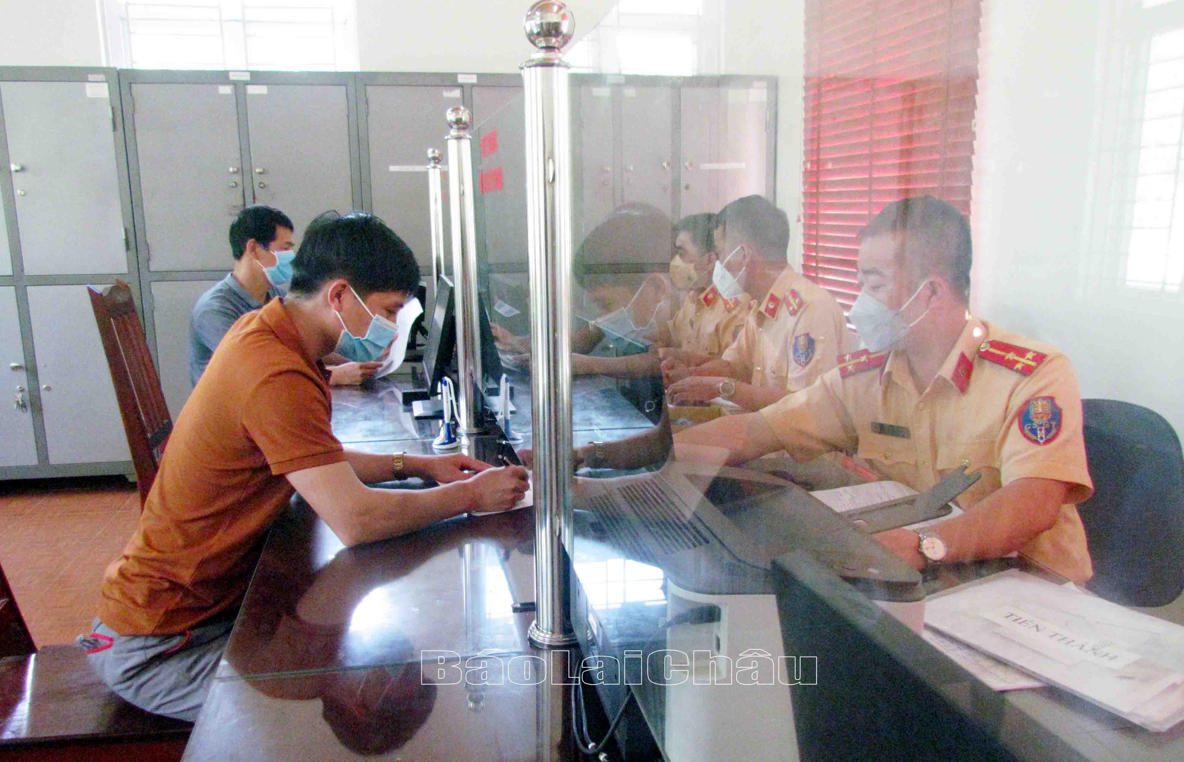 Cán bộ Đội Cảnh sát giao thông trật tự (Công an huyện Phong Thổ) hướng dẫn người dân làm thủ tục đăng ký xe máy.